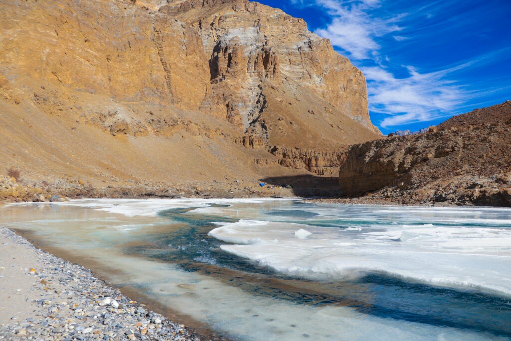 Capture the stunning icy river and rugged mountains of Ladakh's Chadar Trek in winter.
